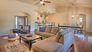A spacious living room with a large sectional sofa, a coffee table, and a dining area with a long table and chairs. - 'mount Elden Retreat:' 4 Mi to Dtwn Flagstaff (Flagstaff)