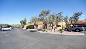 A parking lot with several cars, a building with a red roof, and trees. - Scottsdale Home: Pool Access, 13 Mi to Phoenix (Scottsdale)