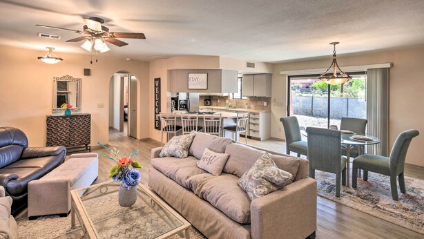 A spacious living room with a sofa, coffee table, and a dining area with chairs and a table. - Lake Havasu City Home w/ Views: 3 Mi to Marina! (Lake Havasu City)