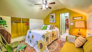 A bedroom with a bed, a ceiling fan, a green sofa, and a lamp. - Colorful Sugar City Apartment ~ 4 Mi to Byu! (Sugar City)