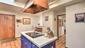 A kitchen with a central island, a wooden cabinet, a sink, and a copper range hood. - Beautiful 'saguaro Vista' w/ Mountain Views! (Tucson)