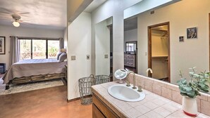 A bedroom with a bed, a bathroom with a sink, and a large mirror. - Beautiful 'saguaro Vista' w/ Mountain Views! (Tucson)