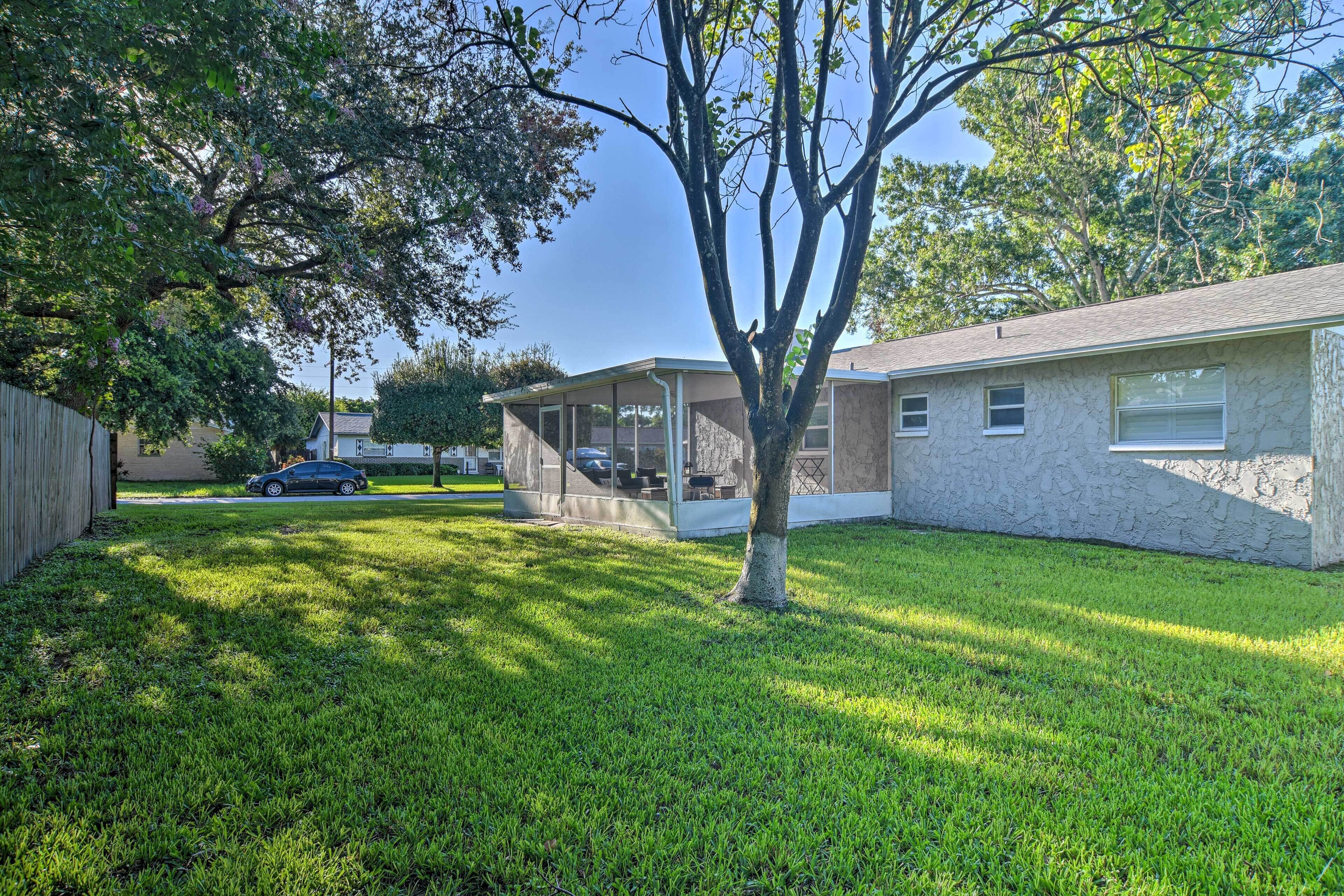A residential house with a covered patio, a lawn, and a car parked in the driveway.