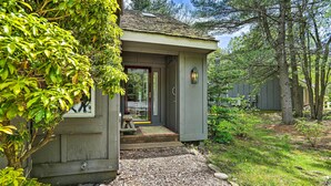 A small, single-story building with a front porch, a visible door, and a small table.