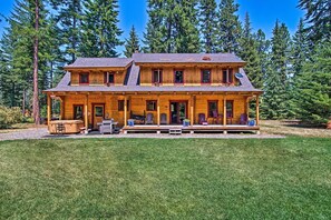 A two-story log cabin with a porch, outdoor seating, and a satellite dish. - Cle Elum Mountain Cabin w/ Hot Tub & Hiking! (Cle Elum)