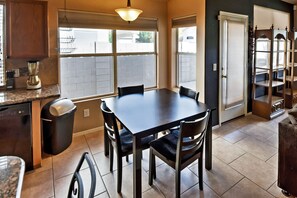 A kitchen with a dining table, chairs, a trash can, and a built-in oven. - 5 Mi to Spring Training: Family Home w/ Grill (Peoria)