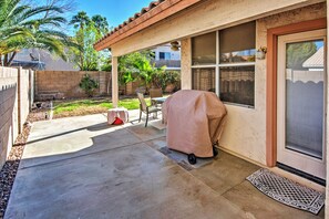 A covered patio with a grill, a door with a window, and a concrete pathway. - 5 Mi to Spring Training: Family Home w/ Grill (Peoria)