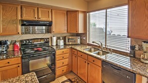 A kitchen with wooden cabinets, a granite countertop, stainless steel appliances, and a window with blinds. - 5 Mi to Spring Training: Family Home w/ Grill (Peoria)