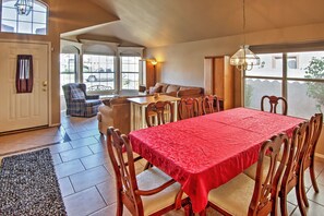 A dining area with a red tablecloth, wooden chairs, and a bench. - 5 Mi to Spring Training: Family Home w/ Grill (Peoria)