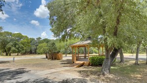 A gazebo with a wooden roof and a bench, surrounded by trees and a gravel path. - Wimberley Retreat w/ Grill < 2 Mi to Jacob's Well! (Wimberley)