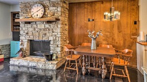 A dining area with a stone fireplace, wooden dining table, and chairs. - Wimberley Retreat w/ Grill < 2 Mi to Jacob's Well! (Wimberley)