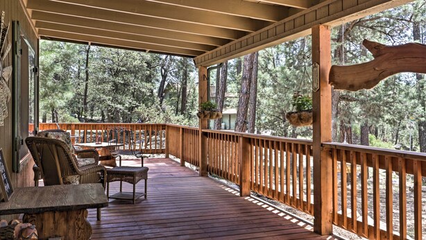 A wooden deck with wicker furniture and a view of a forest. - 'hilda's Cabin' Mtn-view Retreat in Pine! (Pine)