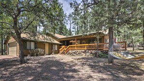 A cabin with a wooden deck, a stone wall, and a hammock. - 'hilda's Cabin' Mtn-view Retreat in Pine! (Pine)