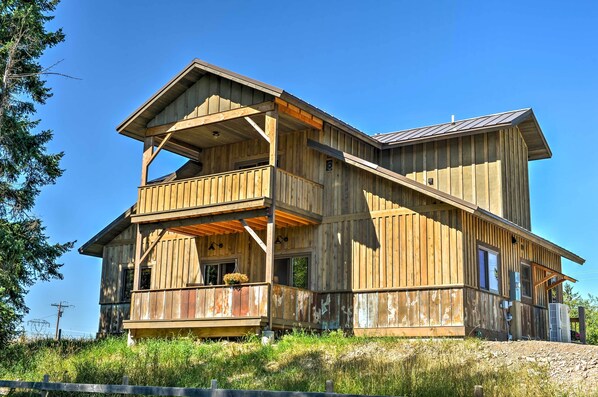 A rustic wooden cabin with a balcony, a second-story deck, and a sloped roof. - Columbia Falls Vacation Rental: 10 Mi to Whitefish (Columbia Falls)