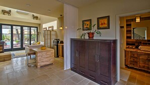 A spacious kitchen with a central island, dark wooden cabinets, and a view to the outdoor patio. - Cozy Casita w/ Mtn View + Pool & Hot Tub Access (Carefree)