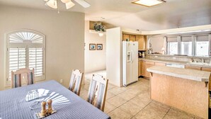 A modern kitchen with a central island, built-in appliances, and a dining area with a table and chairs.