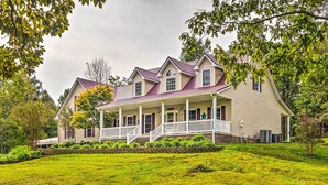 A large, two-story house with a wrap-around porch and a well-maintained lawn. - Mammoth Cave Rental on 50 Acres: Shared Amenities (Mammoth Cave)