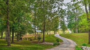 A gravel path winding through a park with trees, a wooden bridge, and a small shelter. - Mammoth Cave Rental on 50 Acres: Shared Amenities (Mammoth Cave)