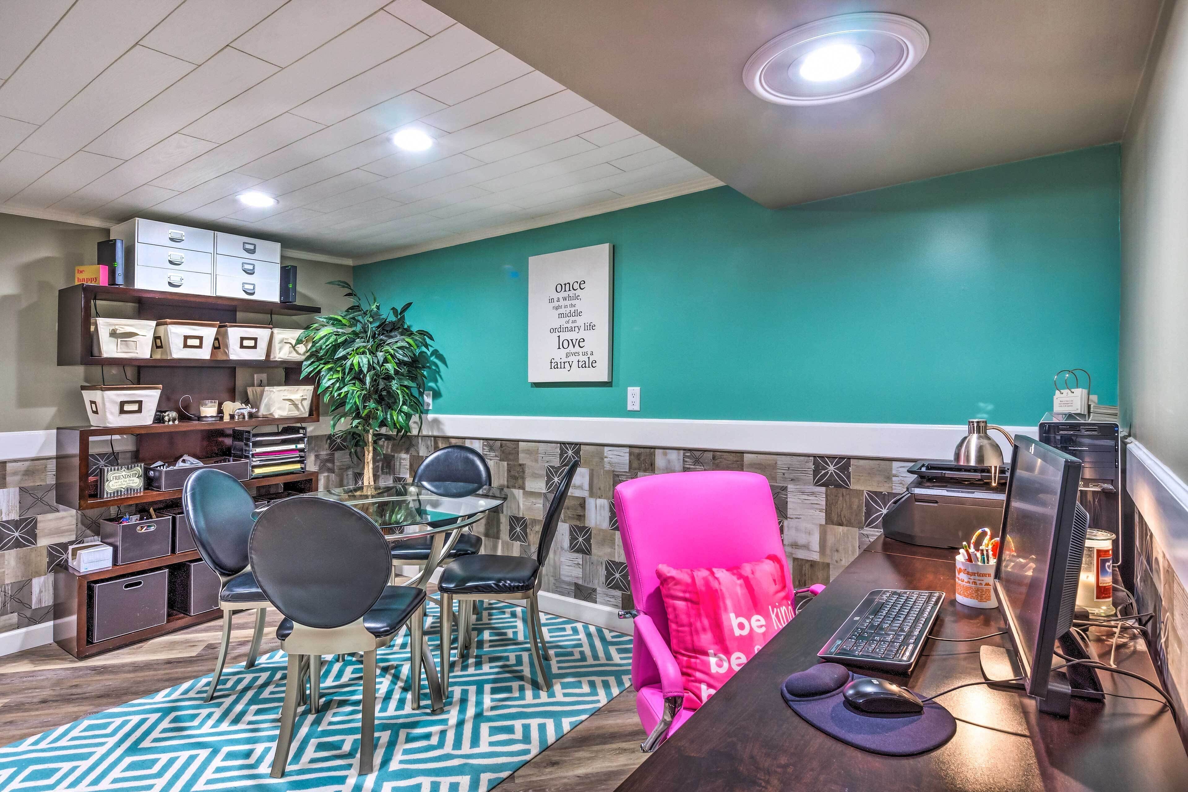 A modern office space with teal walls, a glass desk, and a bright ceiling.