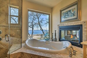 A bathroom with a large bathtub, a glass shower enclosure, a fireplace, and a view of the beach. - 'casa D'amore': Extravagant Lakefront Villa! (Granite Bay)