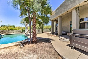 A swimming pool with a palm tree, a barbecue grill, and a building with large windows. - Tucson Desert Oasis w/ Private Pool & Patio! (Tucson)
