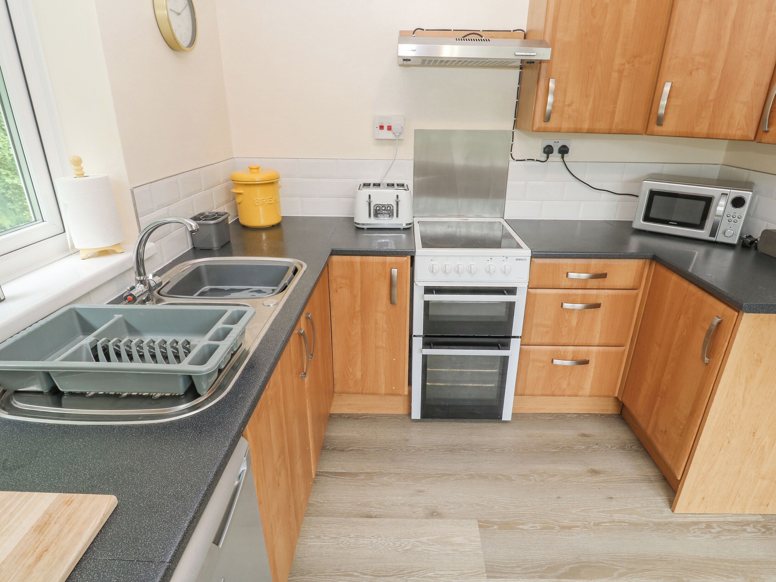 A kitchen with wooden cabinets, a stainless steel stove, a microwave, and a toaster.