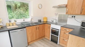 Une cuisine moderne avec des meubles en bois, un four en acier inoxydable et un lave-vaisselle.
