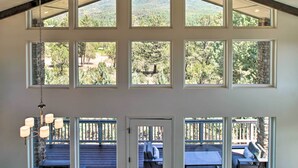 A spacious interior with multiple windows offering views of a mountainous landscape. - Mountain View Modern Cabin: Luxury Pine Home! (Pine)