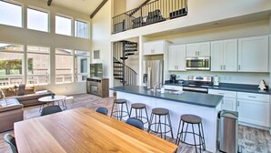 A spacious kitchen with a large island, white cabinets, and a stainless steel range hood. - Mountain View Modern Cabin: Luxury Pine Home! (Pine)