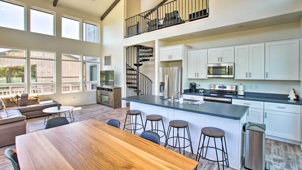 A spacious kitchen with a large island, white cabinets, and a stainless steel range hood. - Mountain View Modern Cabin: Luxury Pine Home! (Pine)