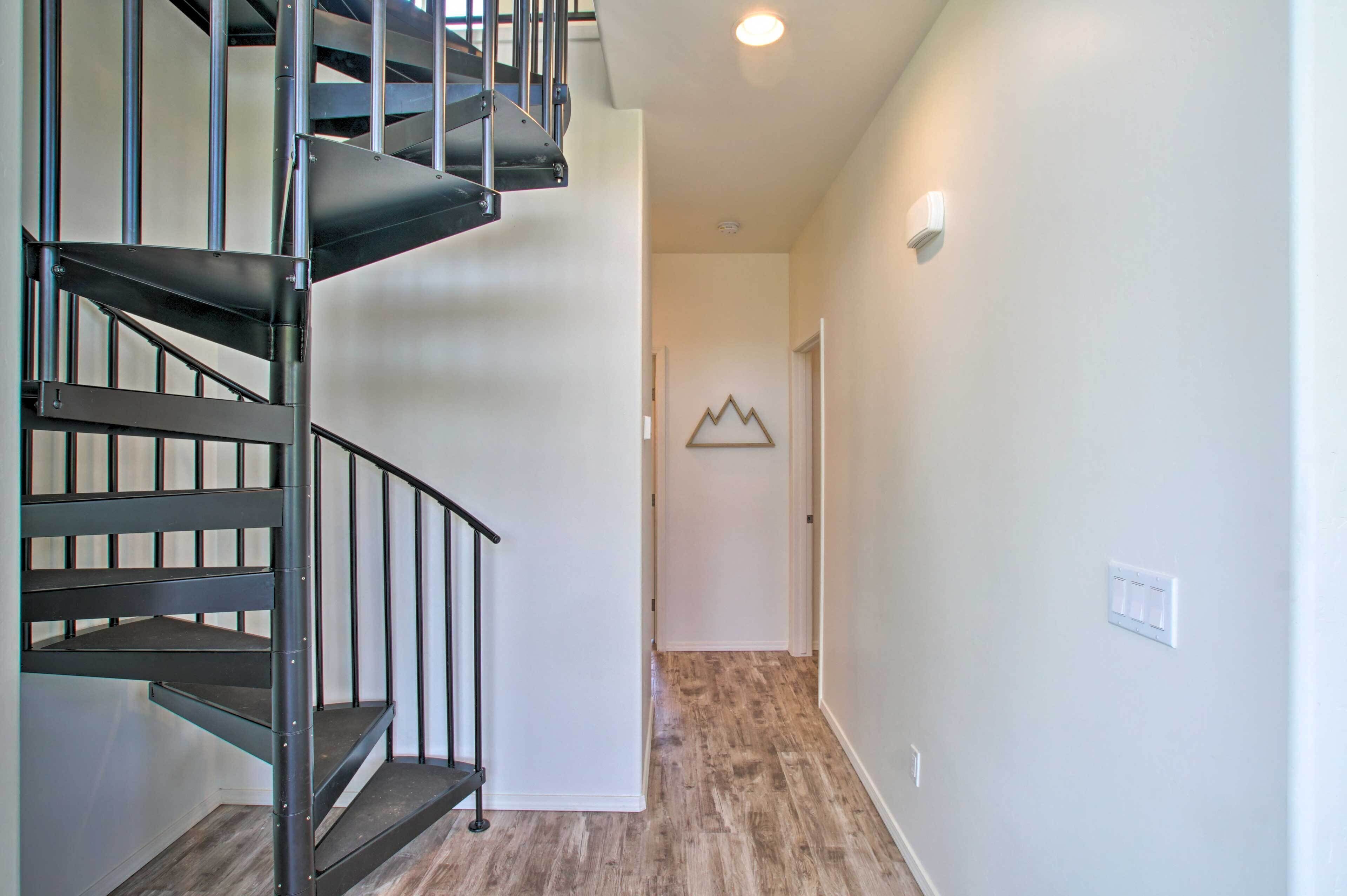A modern interior with a spiral staircase, a wooden floor, and a minimalist decor.