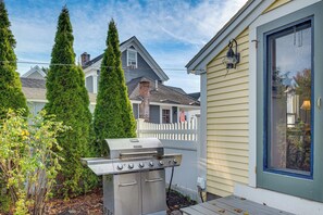 A backyard with a barbecue grill, a wooden deck, and a white picket fence. - < 1 Mi to Beach! Kennebunk Cottage w/ Yard (Kennebunk)