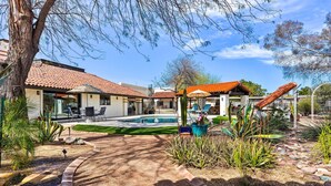 A pool area with a tiled roof, surrounded by plants and a pathway. - Pool & Putting Green: Pet-friendly Glendale Home (Glendale)