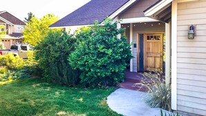 A residential house with a covered porch, a well-maintained lawn, and a driveway. - Family-friendly Bend Home w/ Hot Tub & Yard! (Bend)