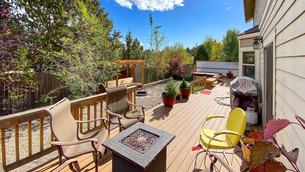 A wooden deck with outdoor furniture, a fire pit, and potted plants. - Family-friendly Bend Home w/ Hot Tub & Yard! (Bend)