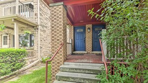 A stone building with a red porch and two blue doors.