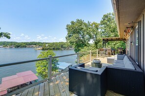 A balcony with wicker furniture, a view of a lake, and a wooden deck. - Hot Tub & Dock! Group Getaway in Lake Ozark (Lake Ozark)