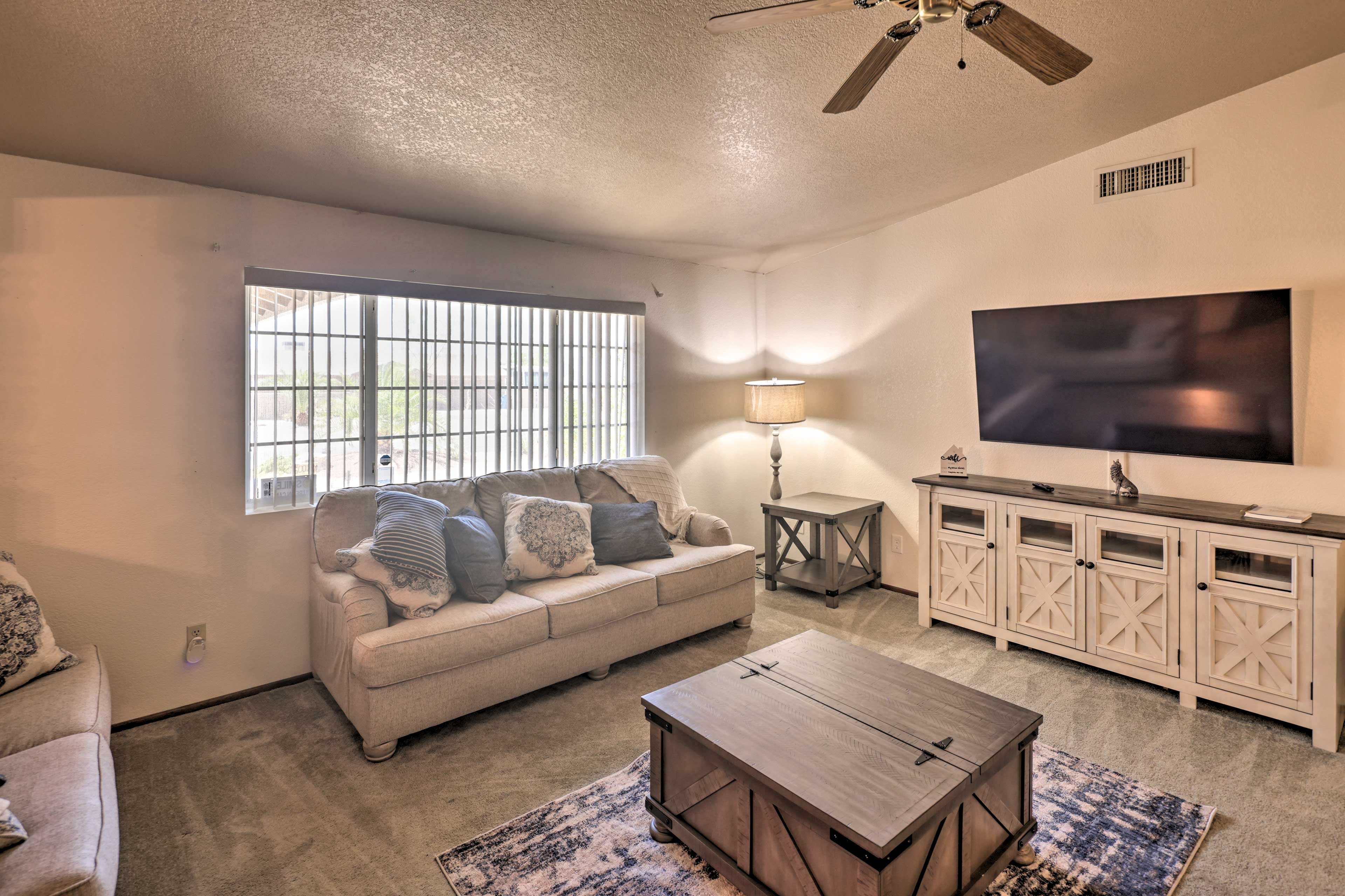 A living room with a sofa, coffee table, TV, and a cabinet.
