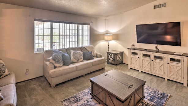 A living room with a sofa, coffee table, TV, and a cabinet. - 4 Mi to Lake Havasu: Luxe Home w/ Outdoor Oasis (Lake Havasu City)