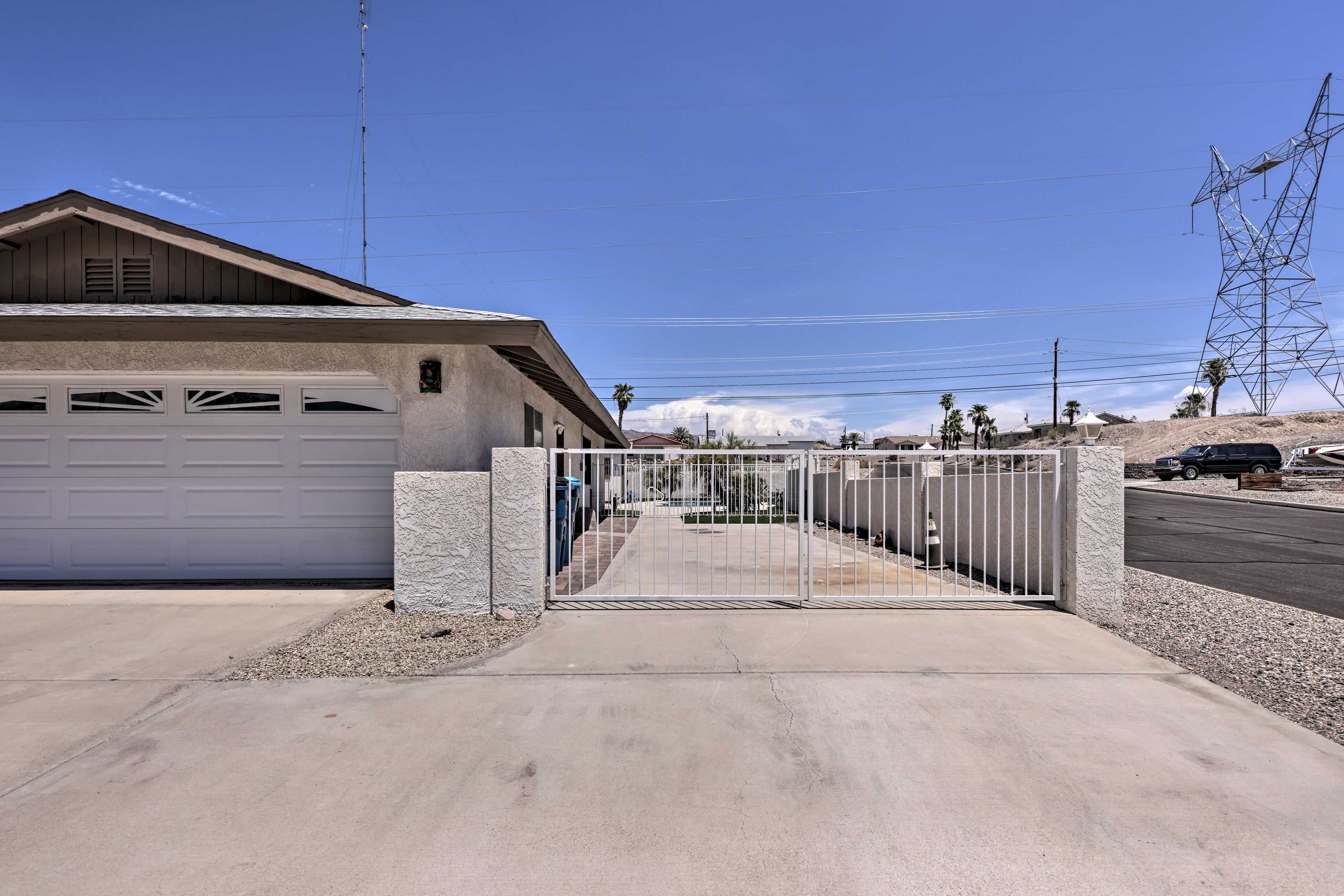 A residential garage with a gated driveway, a utility pole, and a distant power line.