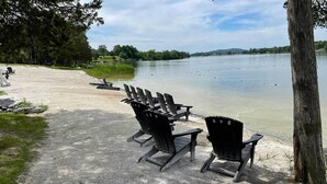 A lakeside area with several Adirondack chairs arranged on a gravel path. - Modern-chic Athens Home - Fish, Ski & Swim! (Athens)