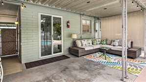 A covered patio area with a sofa set, a small table, and a colorful rug. - Phoenix Desert Getaway: Pool, Grill & EV Charging! (Phoenix)