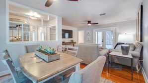 A modern living room with a dining area, a sofa, a coffee table, and a ceiling fan. - Lovely Lubbock Home w/ Furnished Deck & Grill (Lubbock)