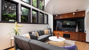 A modern living room with a grey sofa, a coffee table, and a TV in a wooden cabinet. - Outdoor Entertaining Space: Seonda Mtn-view Home (Sedona)