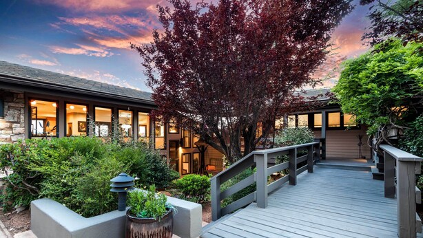 A wooden deck leading to a building with large windows and a stone facade. - Outdoor Entertaining Space: Seonda Mtn-view Home (Sedona)