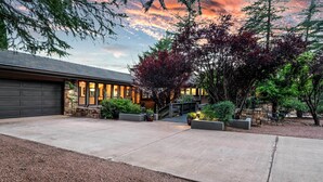 A modern house with a garage, a driveway, and a landscaped garden with trees and shrubs. - Outdoor Entertaining Space: Seonda Mtn-view Home (Sedona)