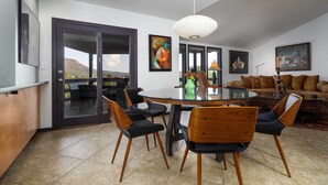 A spacious dining area with a round table, black and wooden chairs, and a view through glass doors to the outside. - Outdoor Entertaining Space: Seonda Mtn-view Home (Sedona)