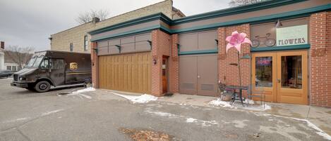 A building with a UPS truck parked in front, a sign reading "Back to the Fuchsia Flowers," and a bicycle leaning against the wall.