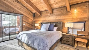 Une chambre dans une cabane en bois, avec un lit, des tables de chevet et une chaise.