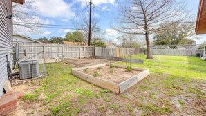 A backyard with raised garden beds, a wooden fence, and a utility shed. - Corpus Christi Extended Stay - 7 Mi to Beach! (Corpus Christi)